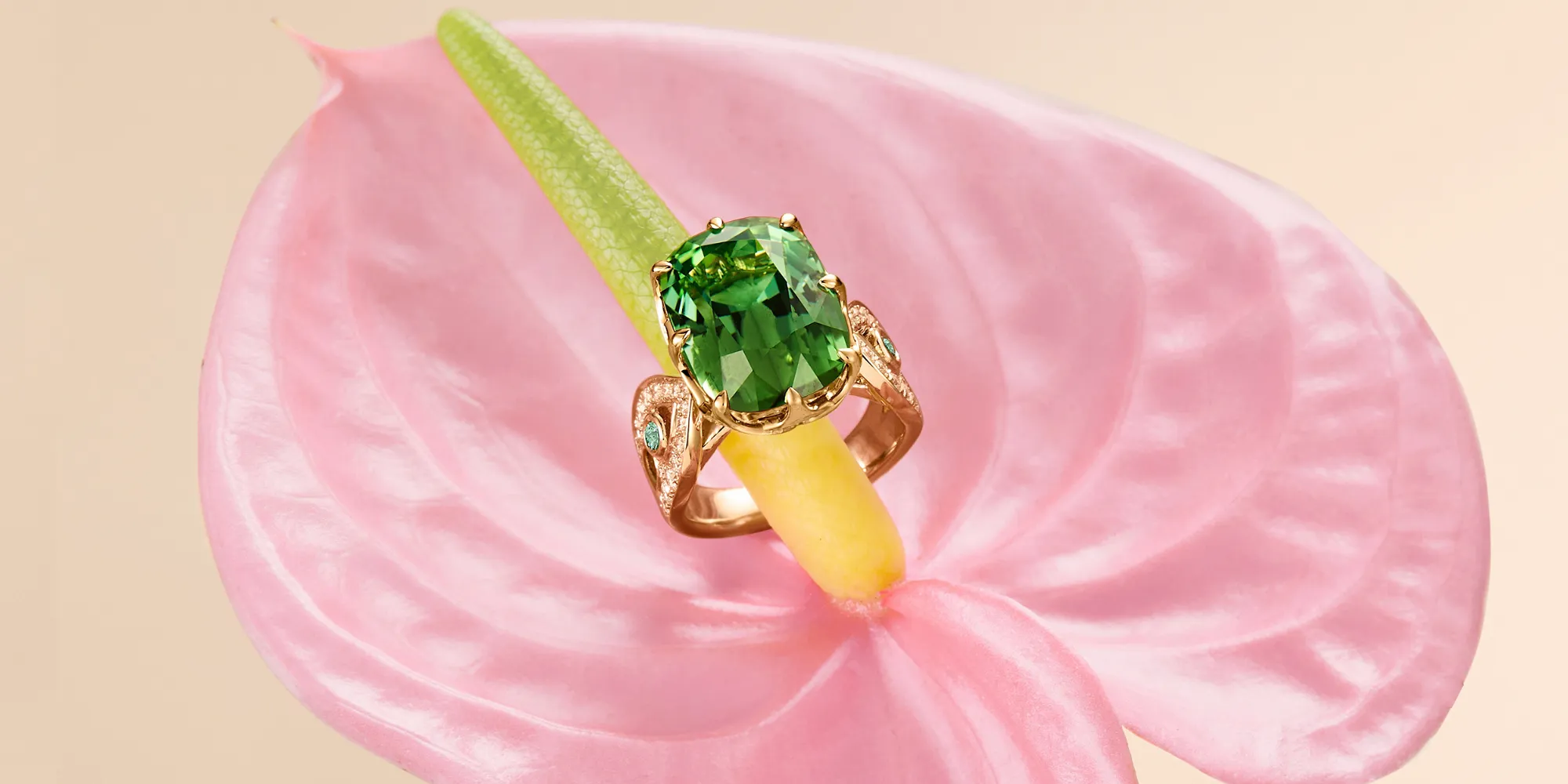 A striking expression of colour, movement and contemporary craftsmanship.
At its centre, a monumental 12-carat cushion-cut Bluish Green Tourmaline is framed by a luminous crown of diamonds, punctuated by vivid Paraiba tourmalines on each side. Crafted in 18K rose gold, its fluid openwork silhouette echoes the organic curves of nature, while a discreet blue accent stone adds a subtle contrast.